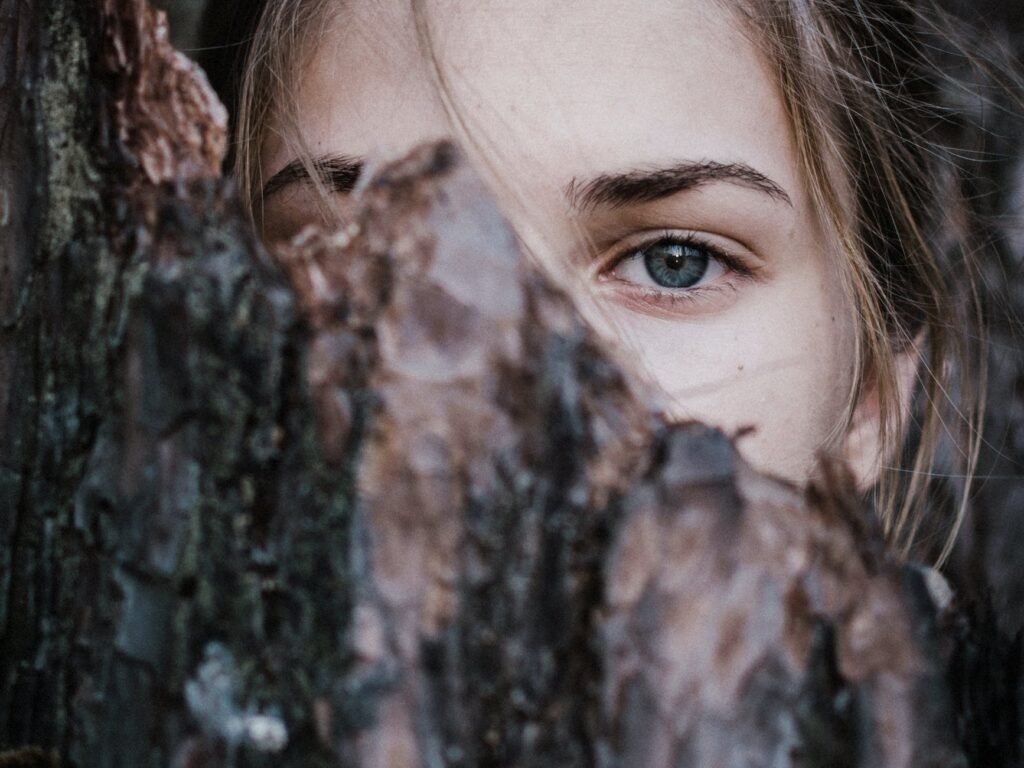 calm woman behind tree bark in park