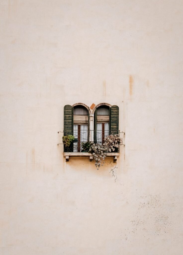 green wooden window on white concrete wall