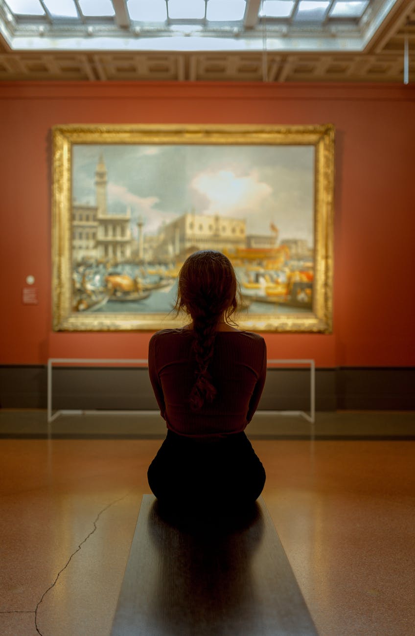 woman sitting in front of a wall painting on an orange wall
